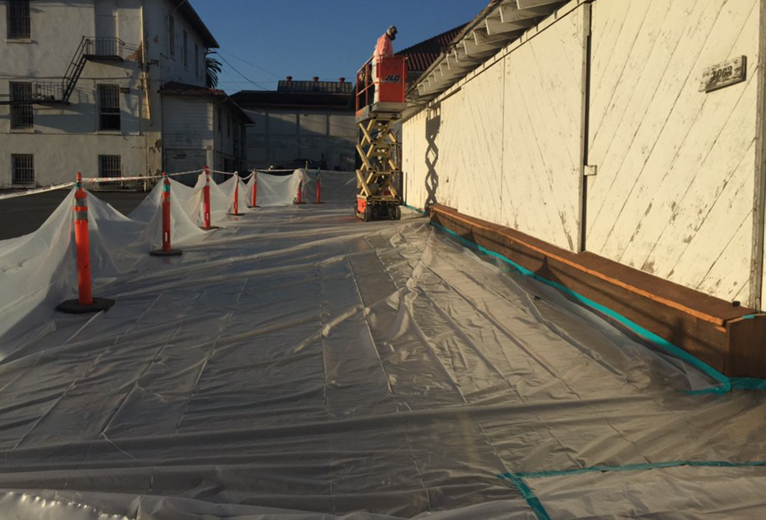 Plastic containment protecting the ground during exterior painting
